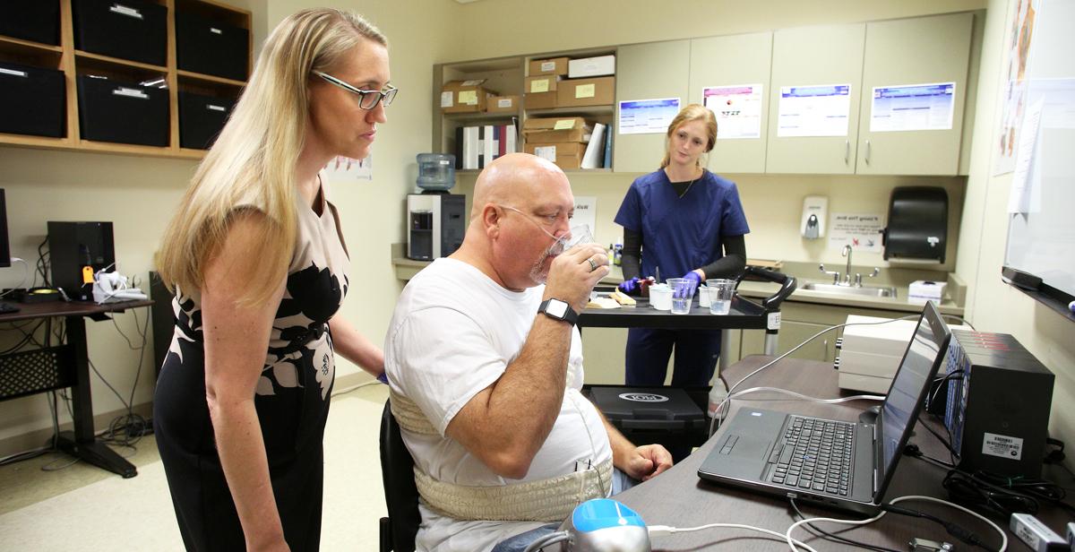 Dr. Kendrea Garand, an assistant professor of speech pathology in the Pat Capps Covey College of Allied Health Professions, works with a volunteer control subject to collect data on swallowing against data collected from an ALS patient. The goal of her research is to improve treatment options for those who suffer from dysphagia.