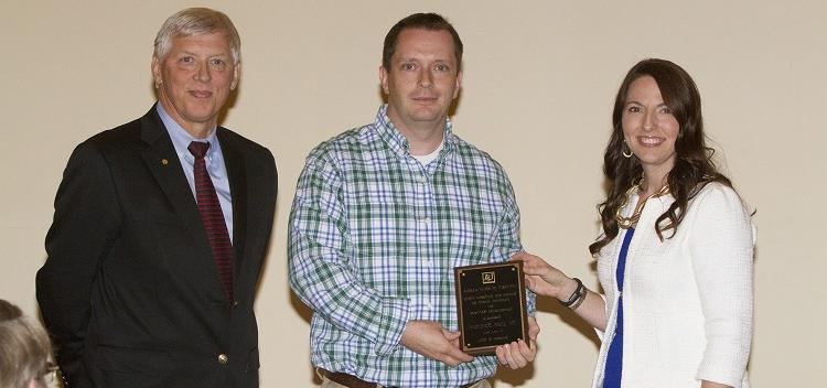 Dr. Julie Estes presents aware to Dr. Glen Borchertand with University President Dr. Tony Waldrop on far right